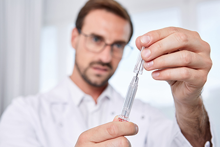 Implant Syringe- doctor removing protective cap doctor removing protective cap from implant syringe